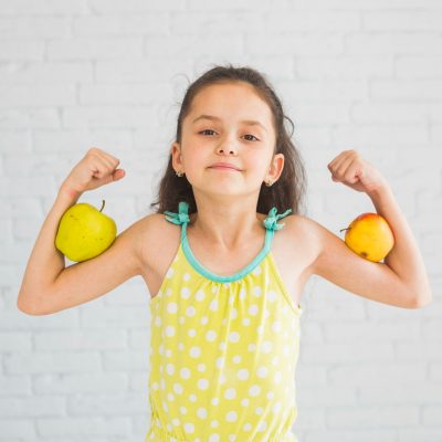 girl-flexing-her-hands-holding-apple-her-biceps (1)